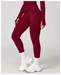 Detail view of burgundy high-waisted yoga pants with ribbed waistband and stretch fabric