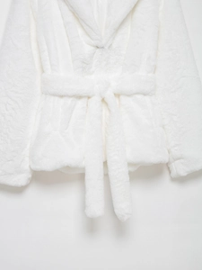 Close-up of white faux fur coat texture with matching plush waist belt detail