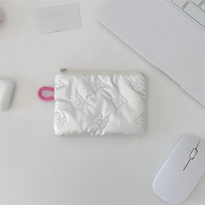 Close-up of white quilted bow texture on portable zippered pouch with a pink wristlet loop