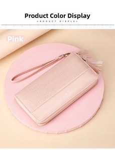 Detail of pink faux leather wallet featuring crocodile texture and lucky clover tassel zip