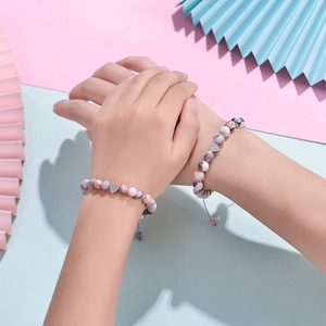 Pink zebra stone beaded bracelet with silver heart charm on hand with gift card
