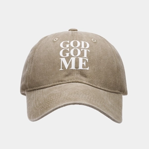 Dettaglio del cappello da baseball in cotone lavato con scritta GOD GOT ME su tessuto kaki