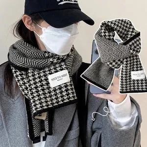 Chunky houndstooth knit scarf in black and white with decorative woven brand tag