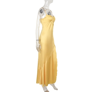 Detail view of the yellow satin strap dress showing pleated chest and silk-like fabric texture