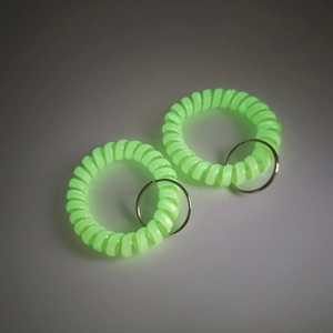 Detailed view of two neon green spiral wrist keychains with metallic split rings