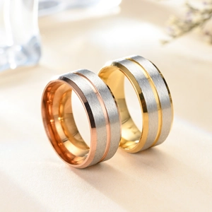 Macro detail of brushed stainless steel ring with rose gold groove and polished edges