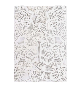 Detail of laser-cut floral pattern on ice white wedding invitation paper card