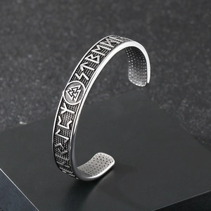 Detailed macro view of Nordic Viking runes and Valknut knot on stainless steel cuff