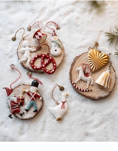 Flat lay of Nordic Christmas tree pendants with Santa and nutcracker on snowy background