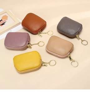 Detailed view of 5 colors of leather mini purses with zipper and metal keychains