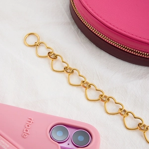 Detail of gold heart chain bracelet with OT toggle clasp on a stylish pink aesthetic setup