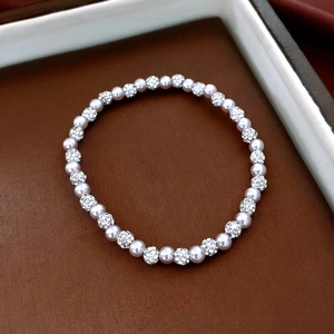 Macro detail of bead bracelet with white pearls and sparkling pavé crystal spheres
