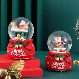 Dreamy Christmas snow globe music box with Santa and reindeer on a red resin base