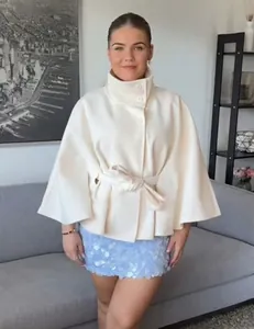 Detailed view of white wool cloak coat with high collar, single-breasted buttons and waist belt