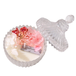 Handcrafted soy wax candle with dried roses and hydrangeas in a vertical striped glass jar