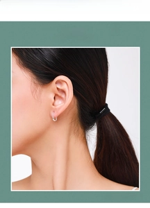 Close-up of minimalist S925 sterling silver hoop earrings worn on a female ear