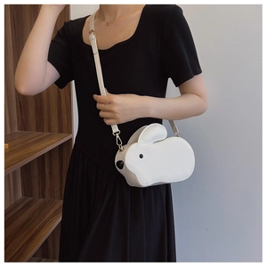 Détail d'un sac à bandoulière blanc en forme de lapin avec chaîne et texture en cuir PU