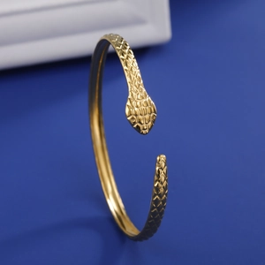 Detail of the golden snake bangle showing intricate scale texture and a polished finish