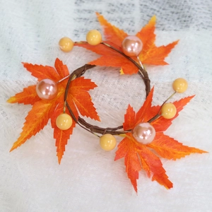 Autumn harvest candle ring featuring realistic orange maple leaves and colorful berries