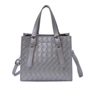 Grey woven texture handbag with dual handles and adjustable shoulder strap on white background