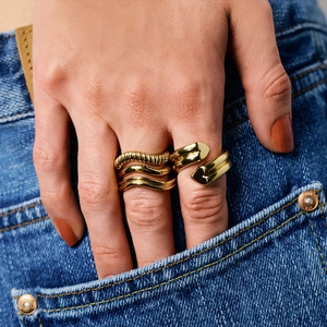 Set aus goldenen Titanstahlringen mit Wellentextur und offenem Design an der Hand