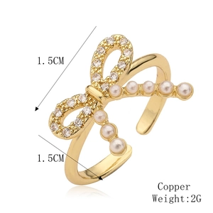 Detail view of a copper bow ring with micro-set zircon and pearls, size 1.5cm width