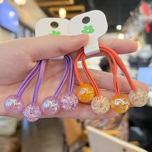 Detail of candy-colored elastic hair ties with glitter and iridescent spherical beads