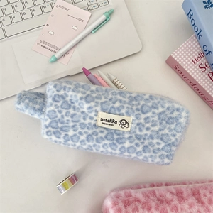Macro shot of fluffy leopard print plush pouch featuring high quality zipper and fabric tag