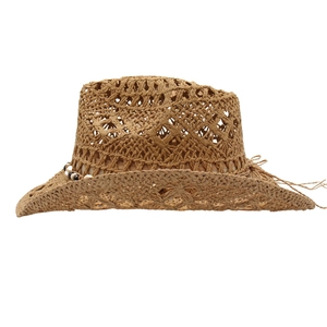 Detail of hand-woven hollow knit straw cowboy hat with decorative beads and wavy brim