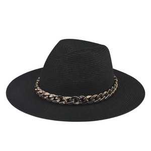 Close-up of black wide brim fedora hat with decorative bold chunky gold metal chain