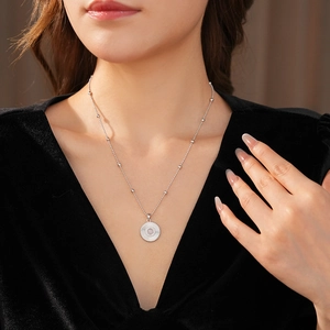 Gros plan d'un collier pendentif marguerite en argent avec zircon sur le cou d'un modèle