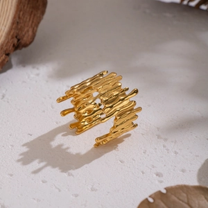 Detailed close-up of golden irregular lava ring on a natural stone and wood display