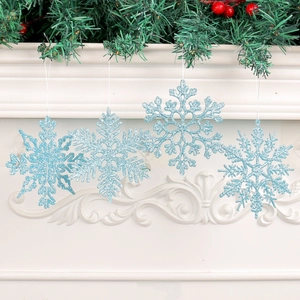 Set of four light blue glitter 10cm snowflake ornaments hanging on a festive fireplace