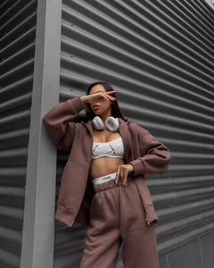 Detail shot of a dark brown knit hoodie set with high-waisted pants on model