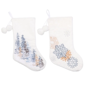 White plush Christmas stockings with embroidered snowflakes and trees, featuring pom-poms