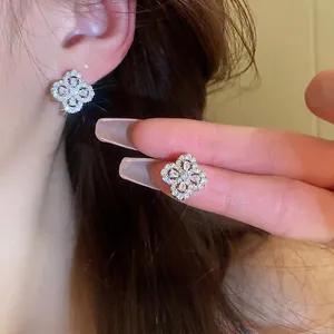 Elegant silver four-leaf clover flower earrings with shimmering cubic zirconia stones