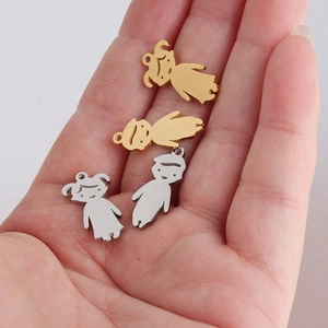 Polished metal boy and girl charms in hand showing actual size of 20mm pendants