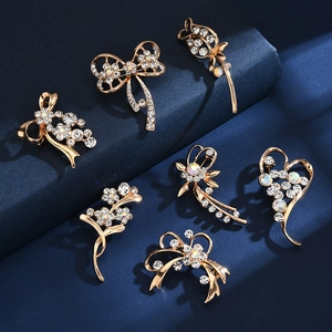 Set of seven gold rhinestone brooches featuring elegant flower and bow-knot designs