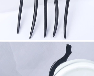 Detail of smooth black ebony-style wood hair pin showing its curved head and fine tips
