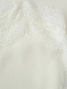 Macro view of white lace trim and smooth satin fabric on a sexy camisole top