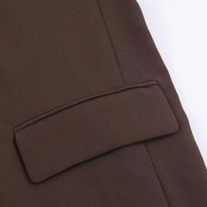 Close-up of a dark brown woven blazer pocket featuring clean stitching and flap detail