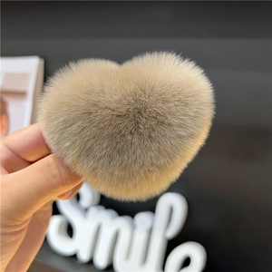 Close-up of light brown heart-shaped faux fur hair clip with soft plush texture