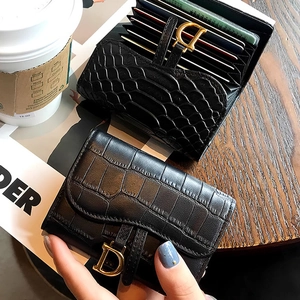 Detail of black crocodile texture men's short wallet with metallic D-buckle on magazines