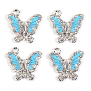Detail of four crystal-encrusted blue butterfly alloy pendants for DIY jewelry making