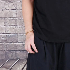 Close-up of a men's golden square pearl hip hop chain bracelet worn on a wrist