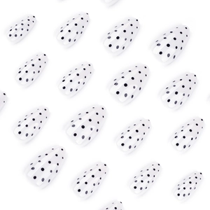 Almond-shaped press-on nails featuring a classic white base with black polka dot patterns