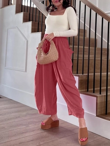 Dettaglio dei pantaloni larghi corallo in cotone e lino a vita alta elastica con ampie tasche