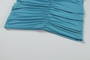 Détail du plissé et de la texture verticale sur une robe d'été dos nu bleu canard