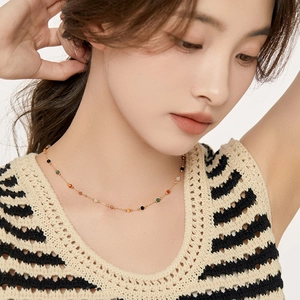 Elegant gold choker necklace featuring colorful natural stone beads worn by a model