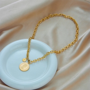Vintage gold portrait coin pendant necklace with chunky chain on champagne silk